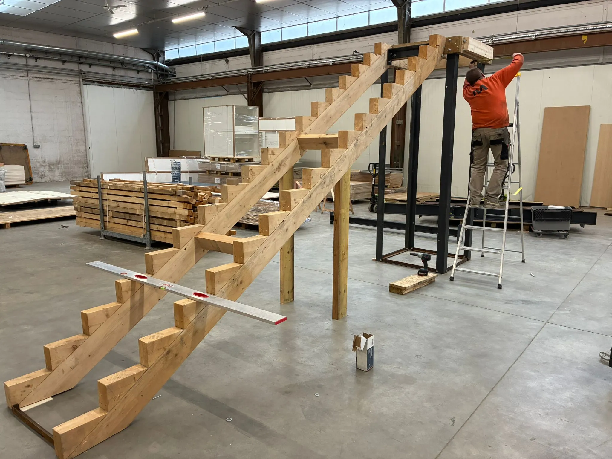 Structure métallique stand étage, fabrication mezzanine stand, montage stand double niveau, charpente acier événementielle, atelier serrurerie Mythiqs, sécurité stand salon, escalier stand sur mesure, note de calcul structure, menuiserie standiste technique