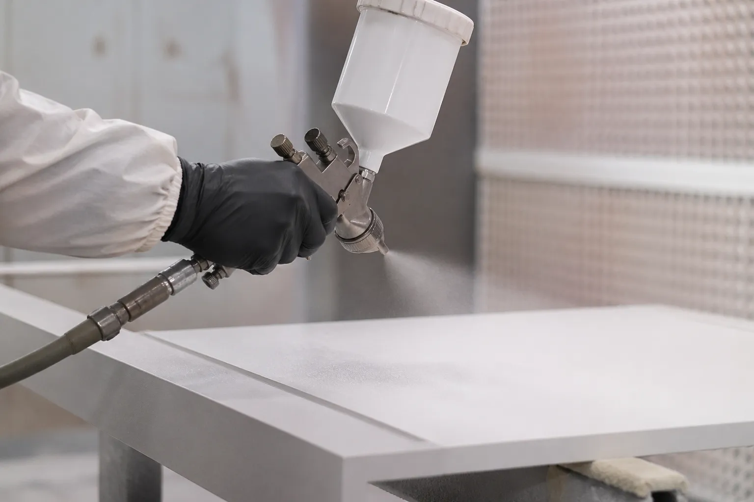 Cabine de peinture industrielle menuiserie, pistolet peinture stand, laquage mobilier stand, finition vernis bois, peintre industriel Mythiqs, respect couleur RAL Pantone, peinture écologique base eau, atelier finition stand Paris.